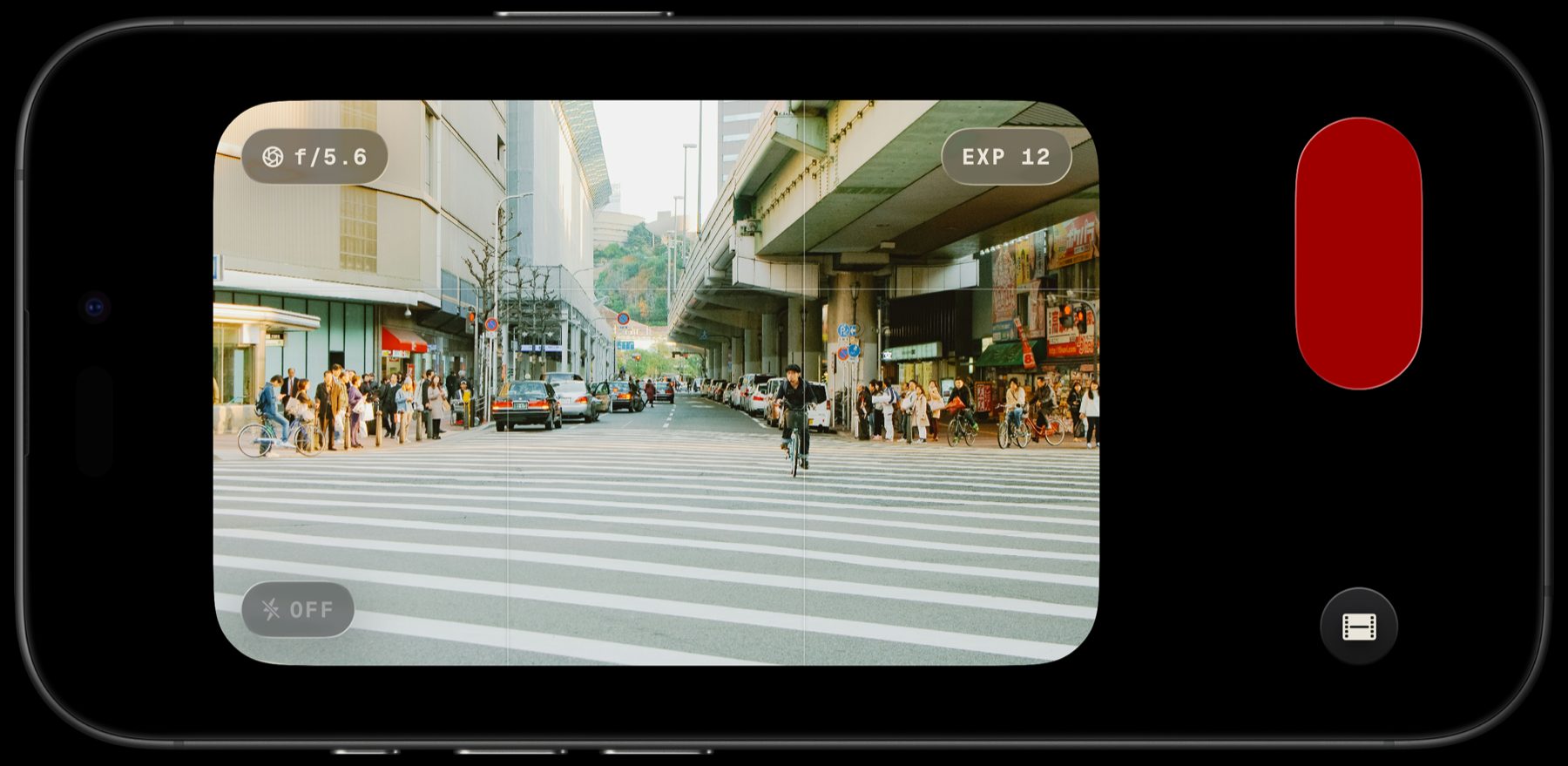 Lupo's camera screen on an iPhone held sideways, showing a street crossing in the viewfinder with aperture, exposure count and flash indicators.